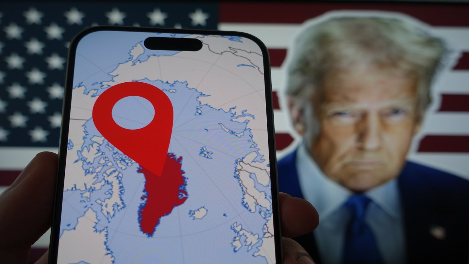 Bojkot produktów z USA w Danii. Trump rozwścieczył Duńczyków zakusami na Grenlandię Telefon z granicami Grenlandii na tle Donalda Trumpa i amerykańskiej flagi. Wściekli Duńczycy bojkotują produkty z USA. To dopowiedź na zakusy Trumpa.