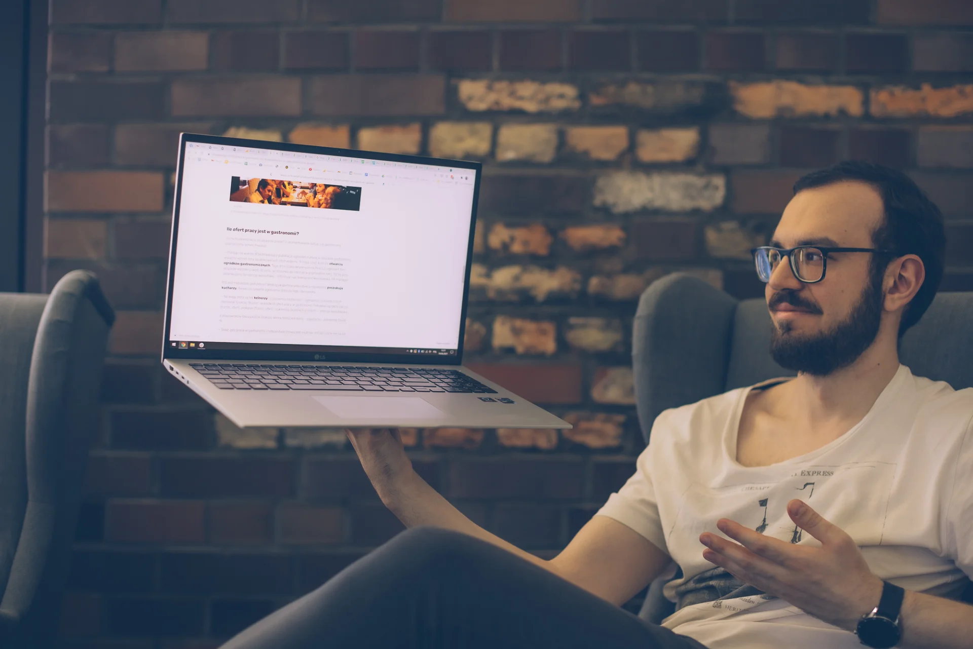 Laptop LG Gram. Mężczyzna trzyma go w jednym ręku.