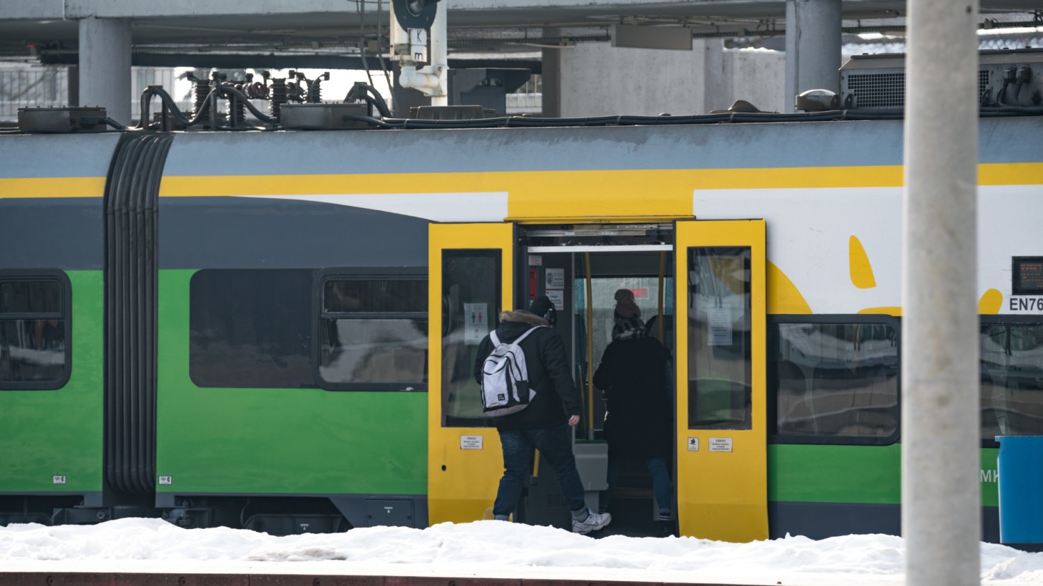 Ludzie wsiadający do pociągu Kolei Mazowieckich. Zima.