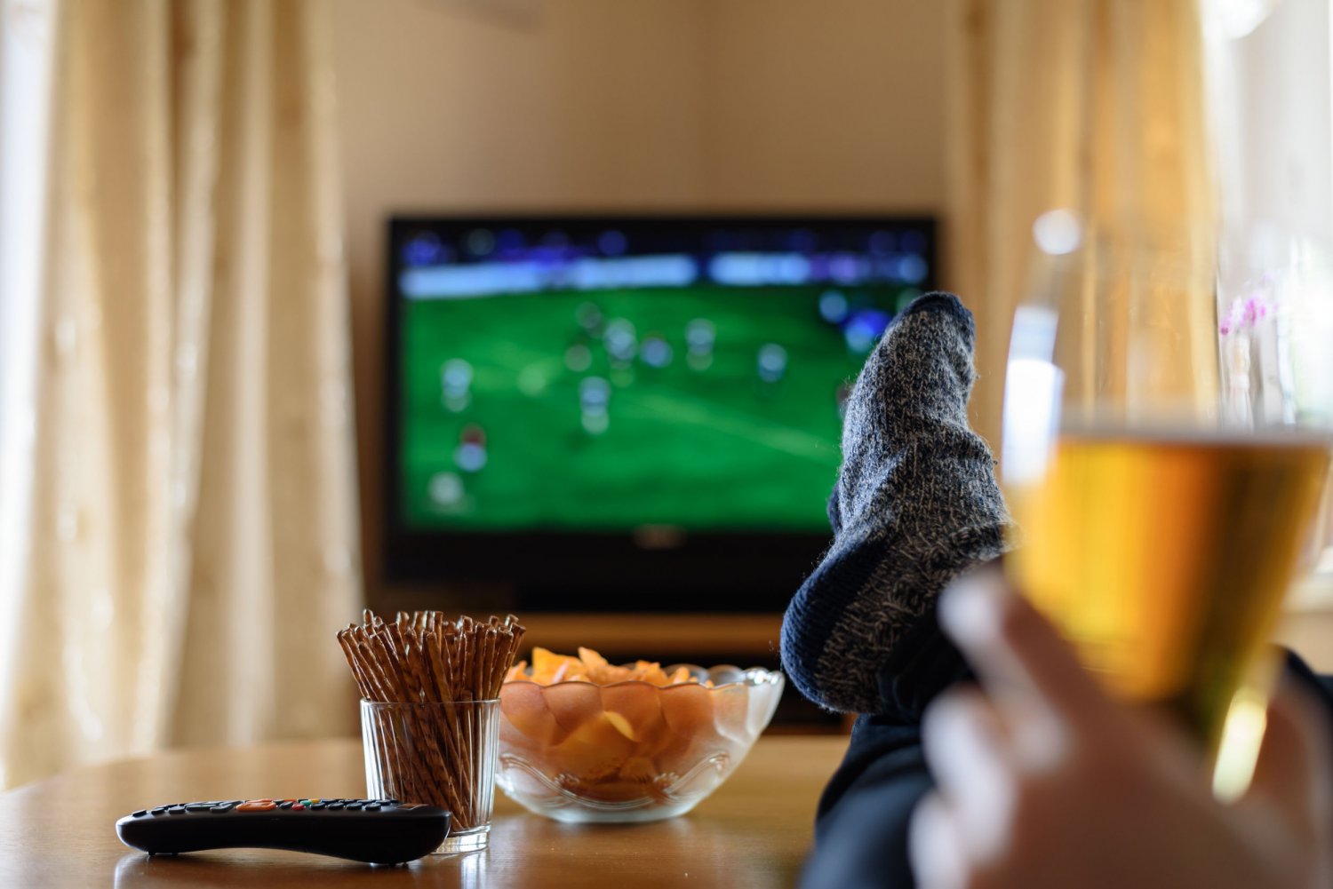 Mężczyzna ogląda mecz na telewizorze