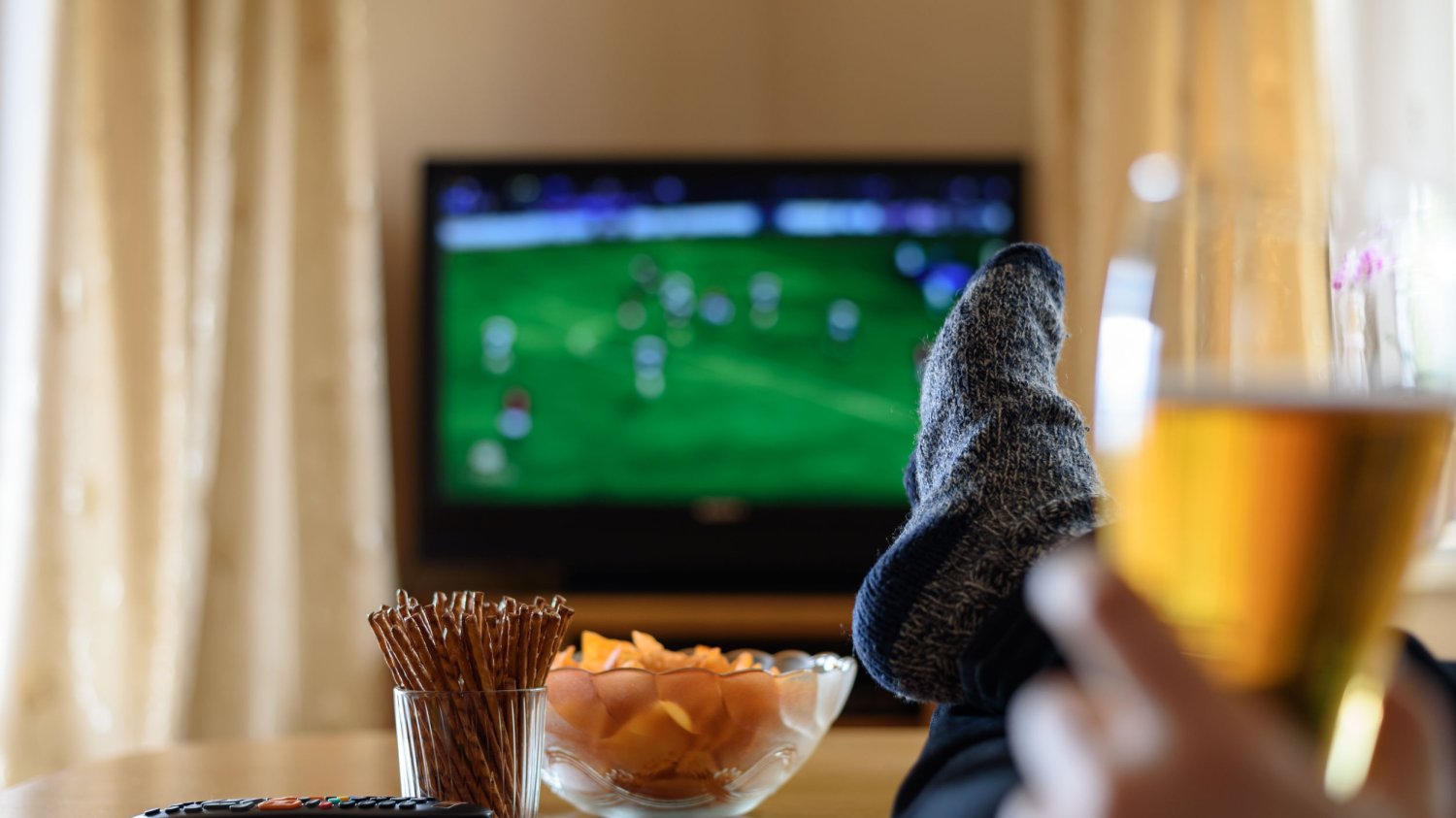 Mężczyzna ogląda mecz na telewizorze