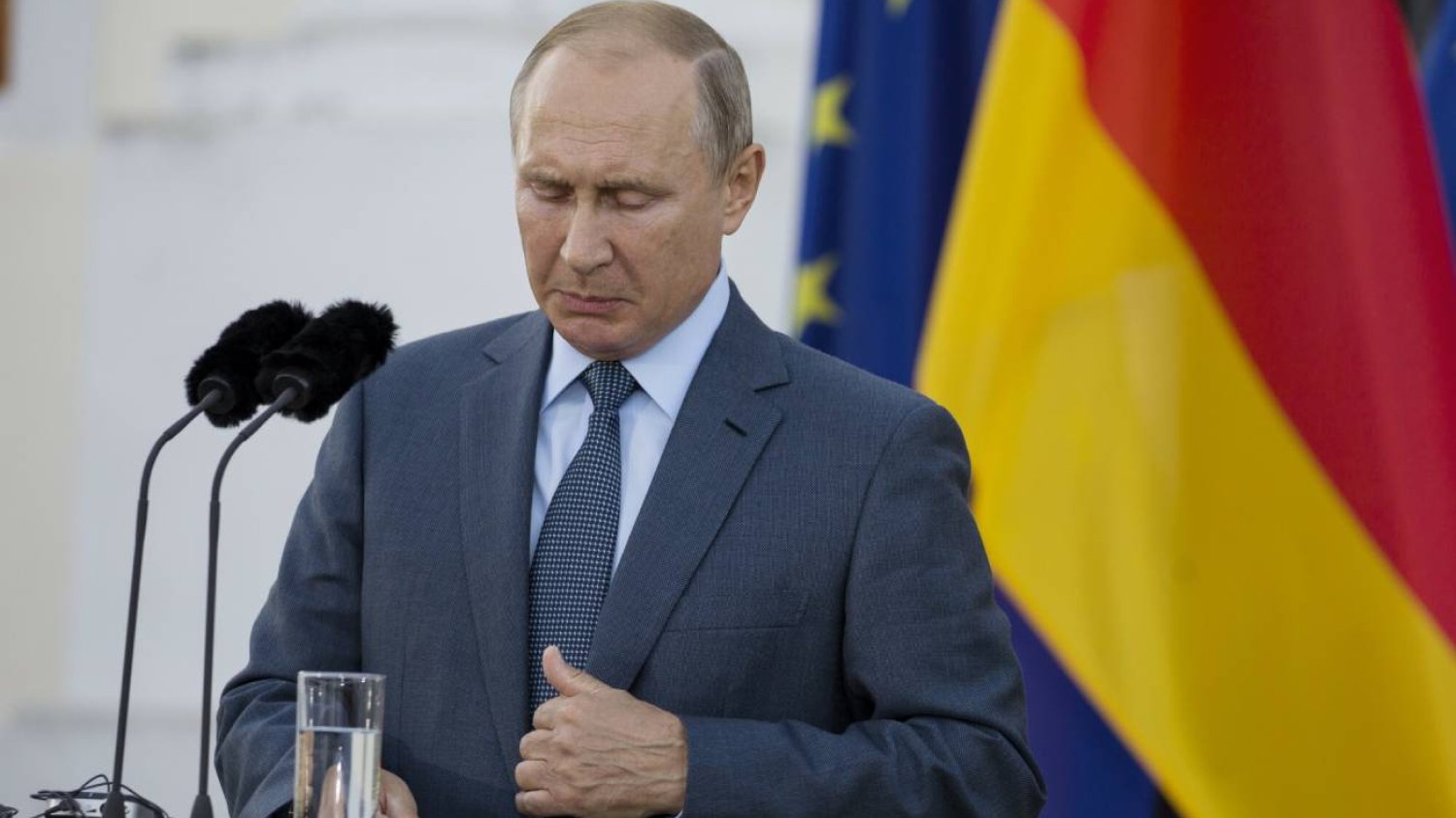 Władimir Putin na tle niemieckiej flagi.