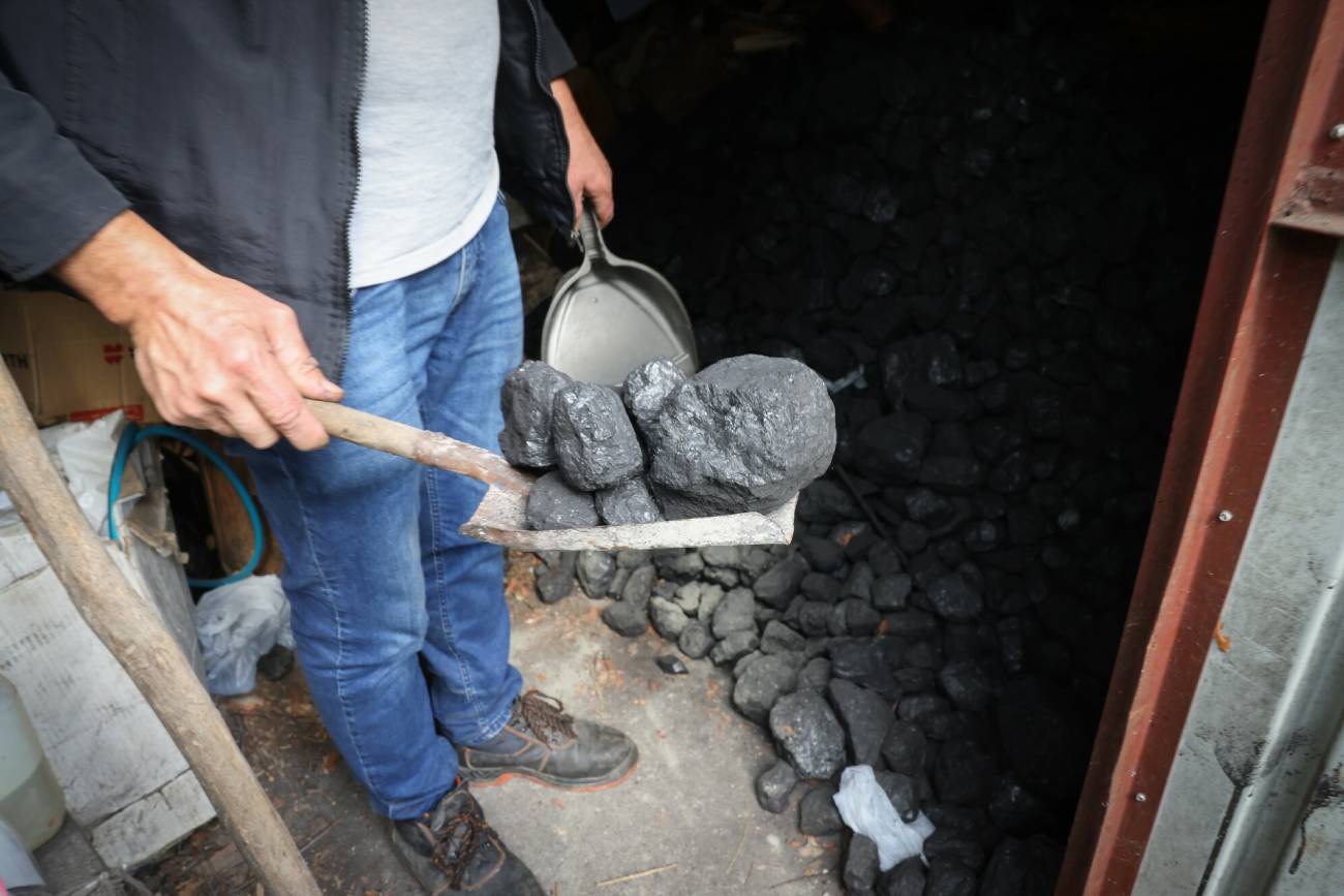 Mężczyzna trzymający łopatę z węglem.