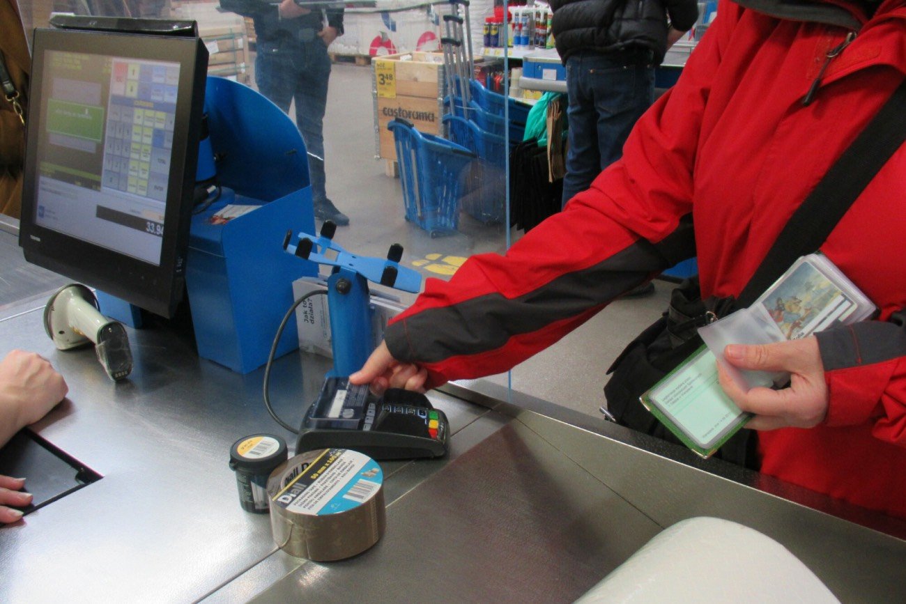 Osoba płacąca kartą przy kasie w sklepie