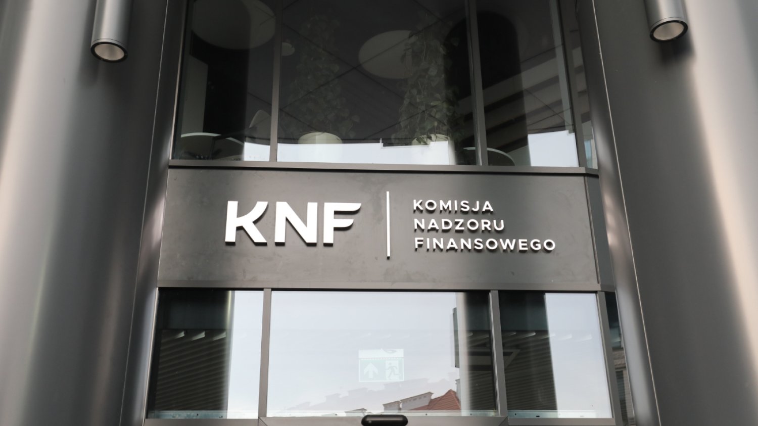 Wejście do siedziby Urzędu KNF, napis "KNF Komisja Nadzoru Finansowego".