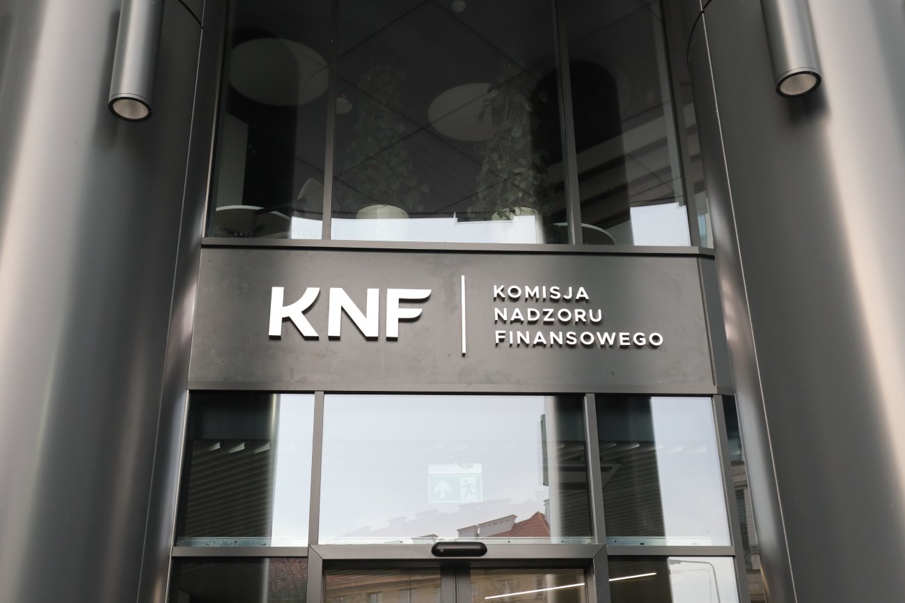 Wejście do siedziby Urzędu KNF, napis "KNF Komisja Nadzoru Finansowego".