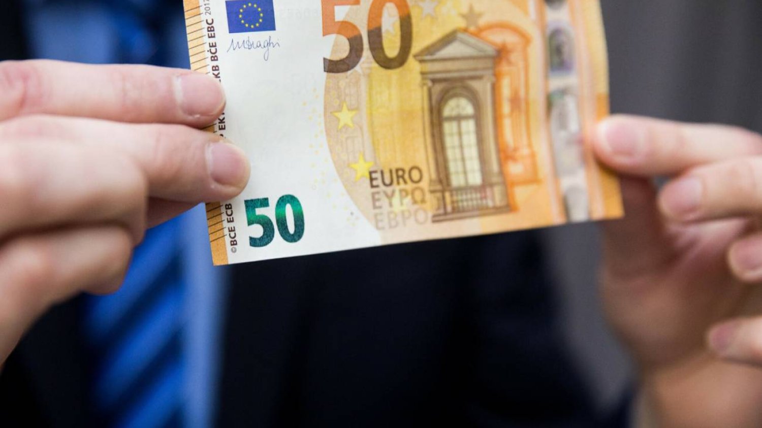 Biznesmen trzyma banknot euro