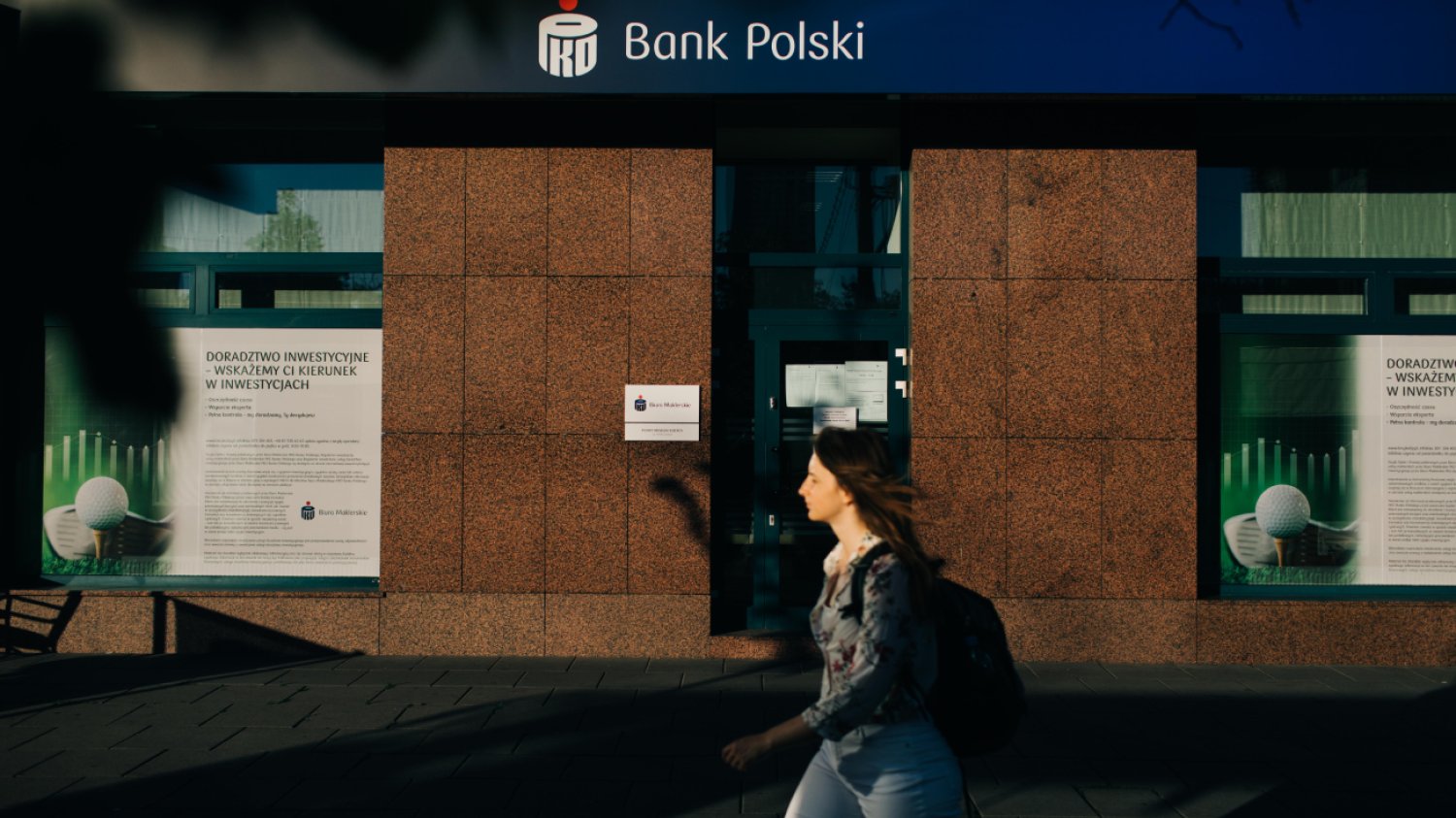 Kobieta przechodząca przed oddziałem PKO