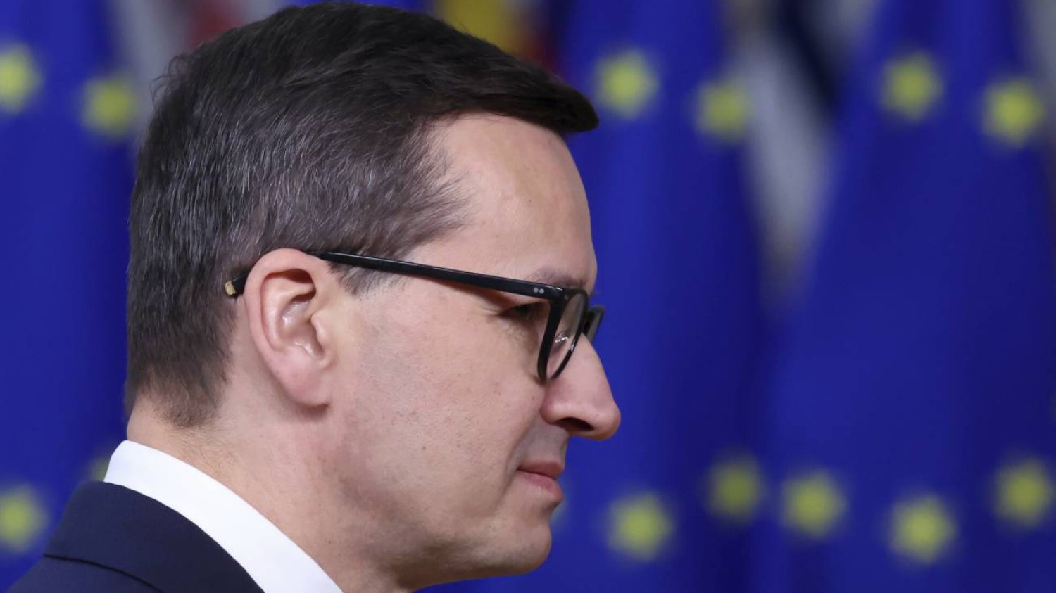 Premier Morawiecki na tle flag UE