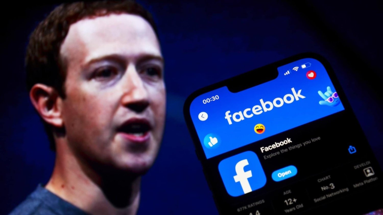W tle prezes spółki Meta Mark Zuckerberg. Na pierwszym planie po prawej stronie telefon z włączonym Facebookiem.