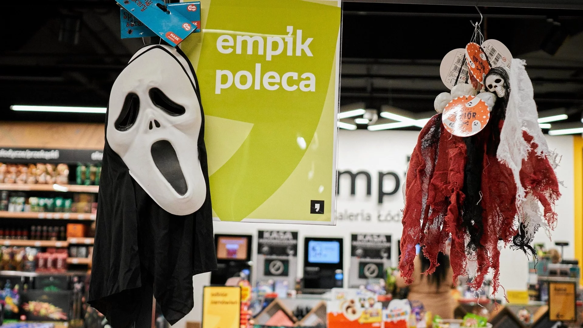 Maski na Halloween w Empiku na tle logo spółki. Empik odda pieniądze klientom za opóźnienia i anulowane zamówienia w latach 2022-2024.