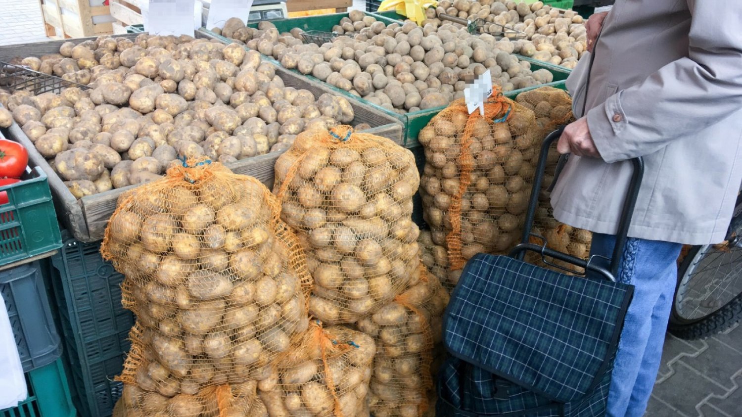 Klientka na rynku stojąca przed ziemniakami