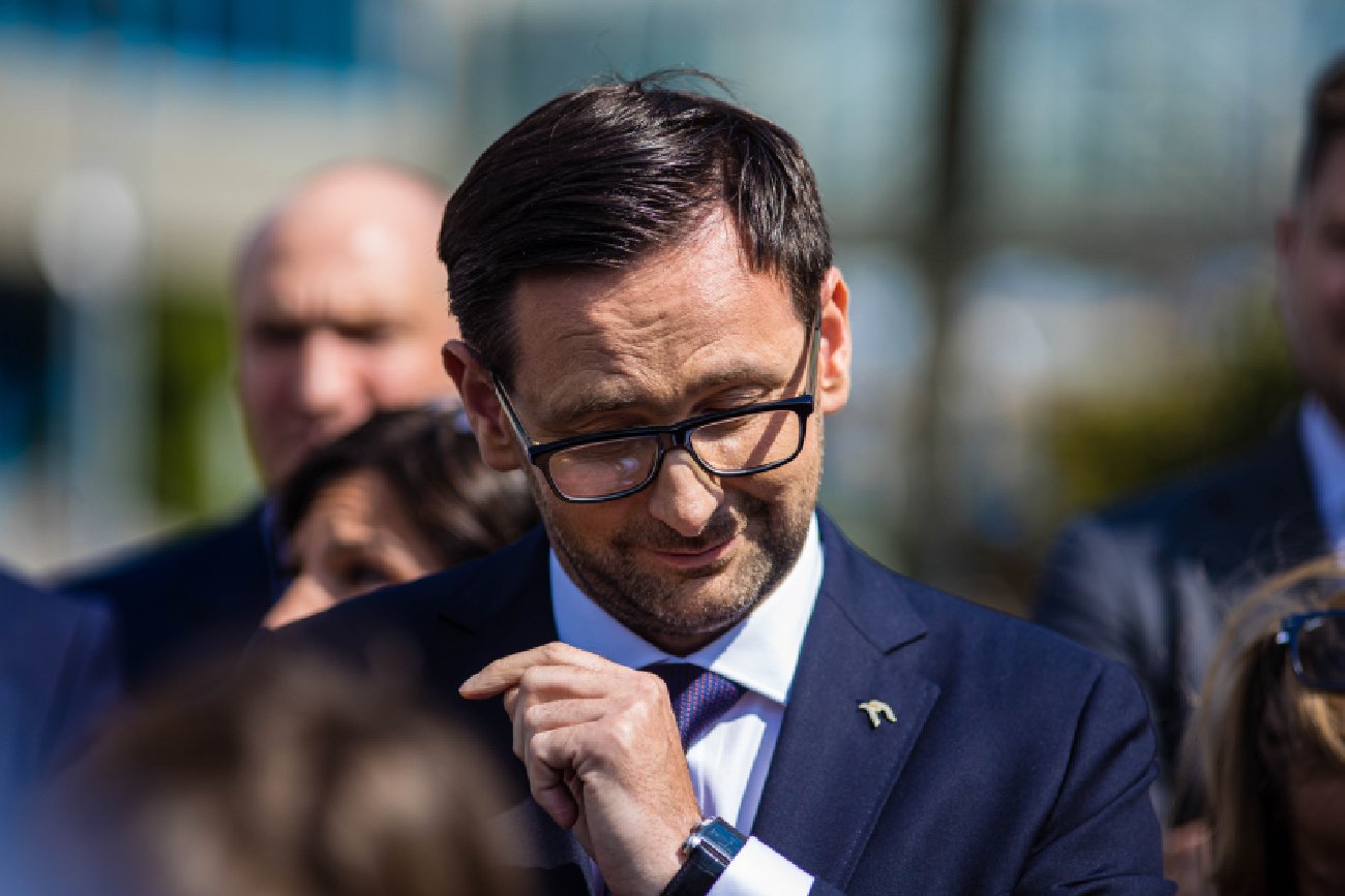 uśmiechnięty Daniel Obajtek ze schyloną głową