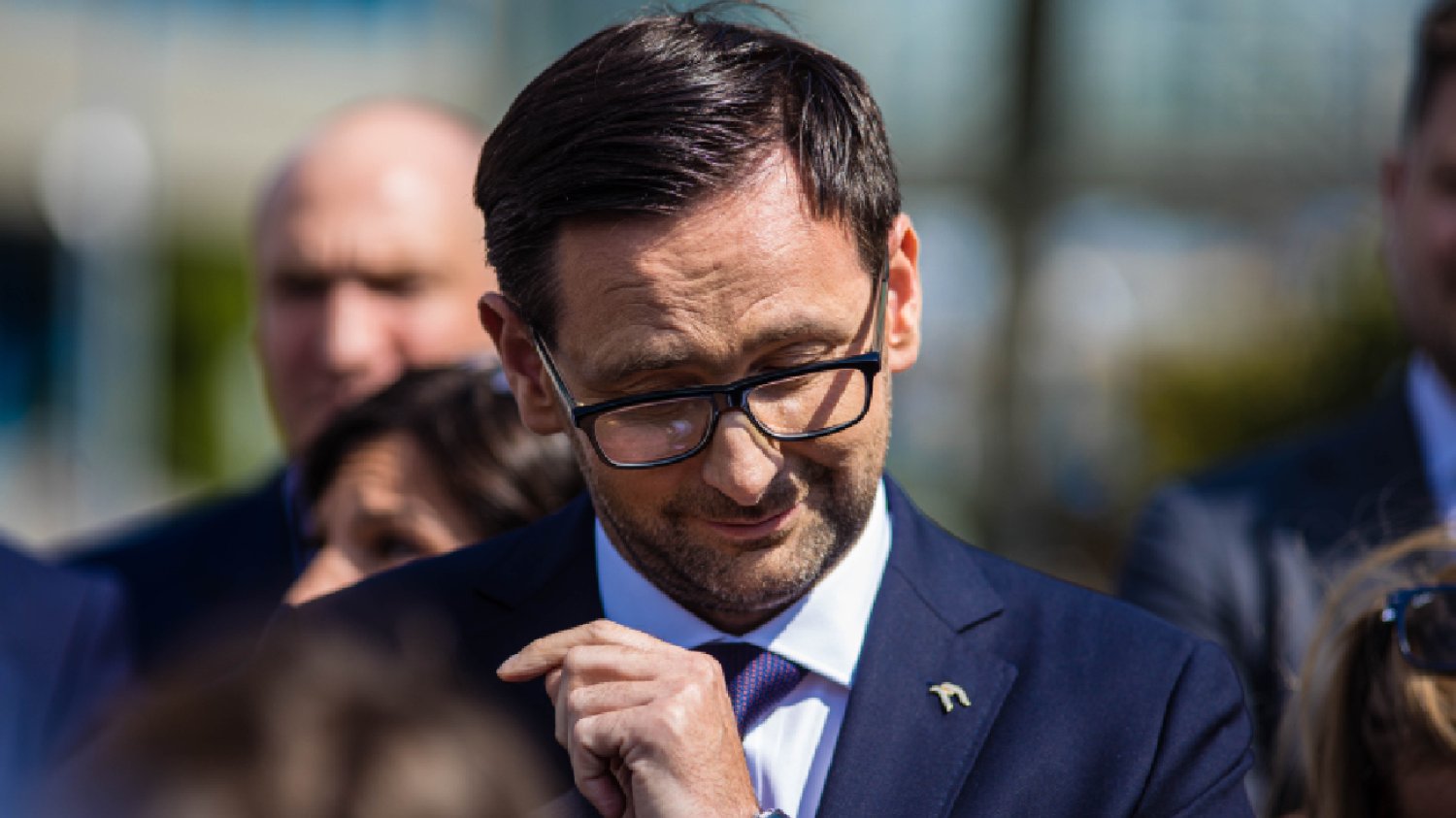 uśmiechnięty Daniel Obajtek ze schyloną głową