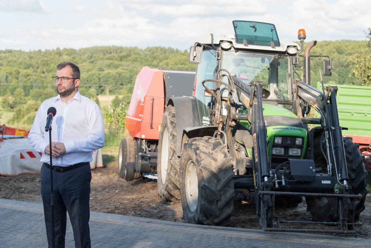 Minister rolnictwa Grzegorz Puda na tle traktora