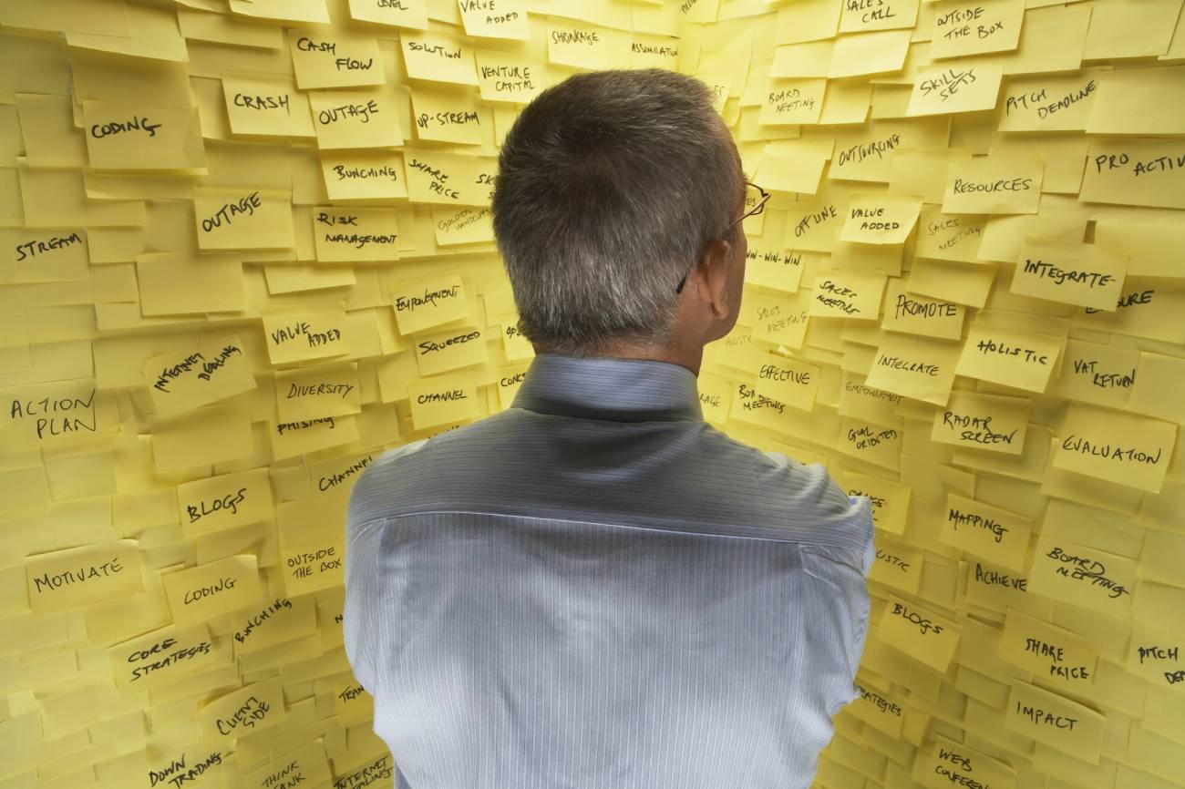 Mężczyzna zagubiony w notatkach.