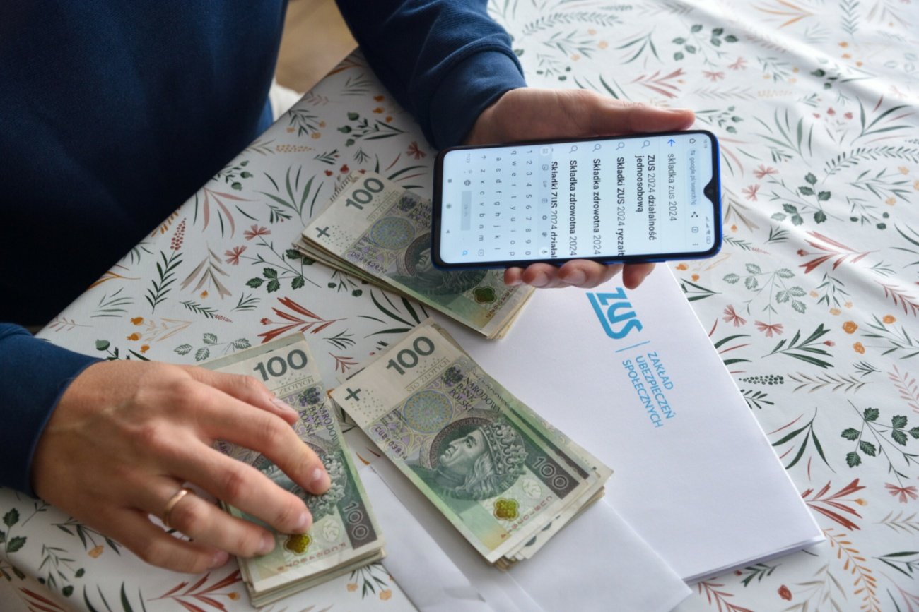 Telefon, banknoty polskie, list z ZUS.