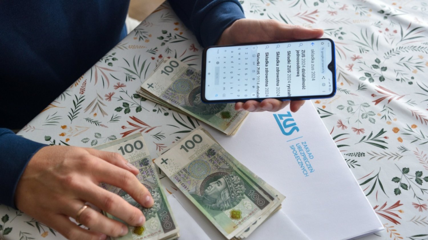 Telefon, banknoty polskie, list z ZUS.