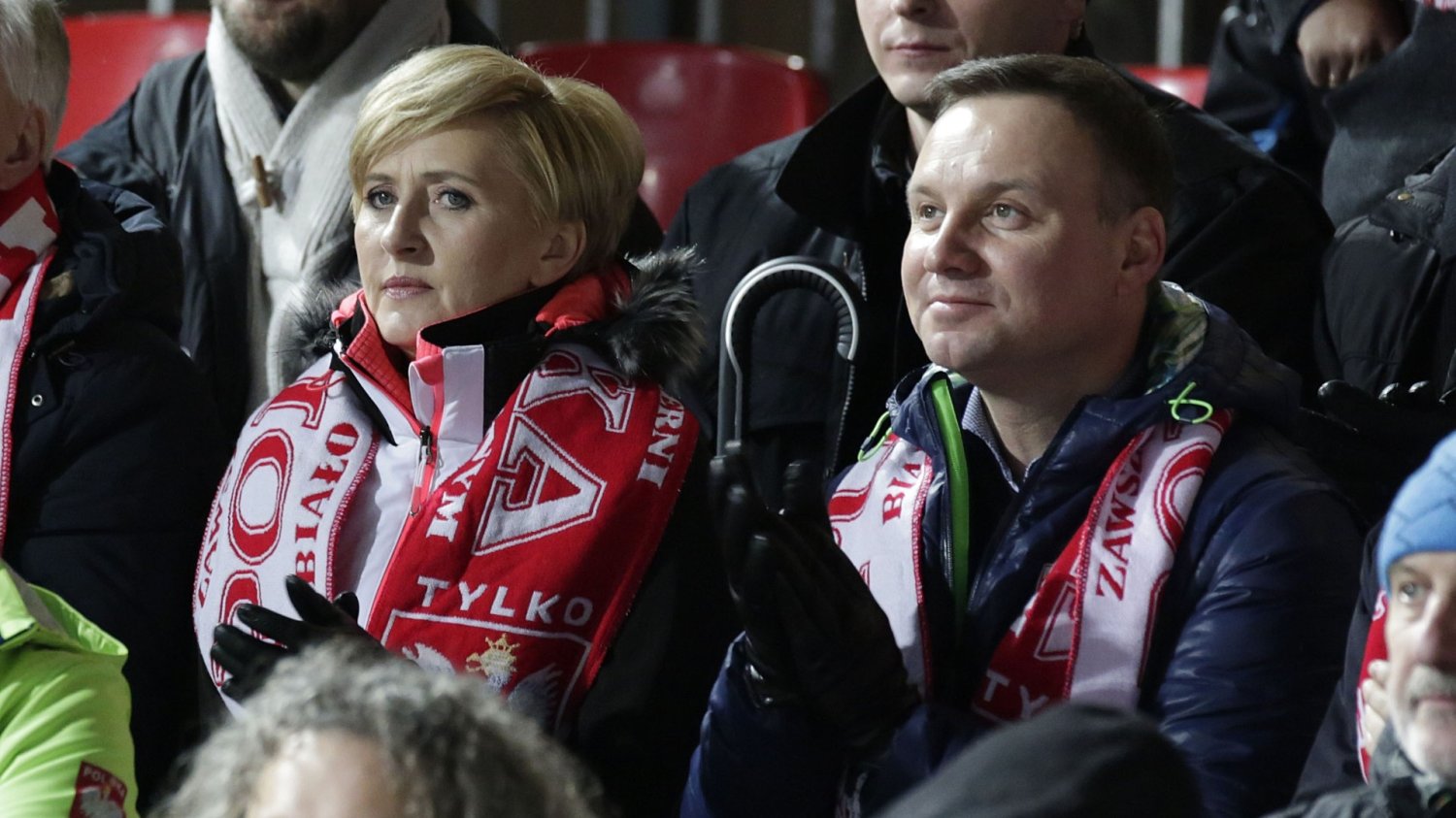 Andrzej Duda założył firmę razem z Agatą Kornhauser-Dudą. Andrzej Duda. Agata Duda. Kibicują Polsce w Zakopanem. Mają szaliki polski na szyi. Wokół śnieg i inni kibice.