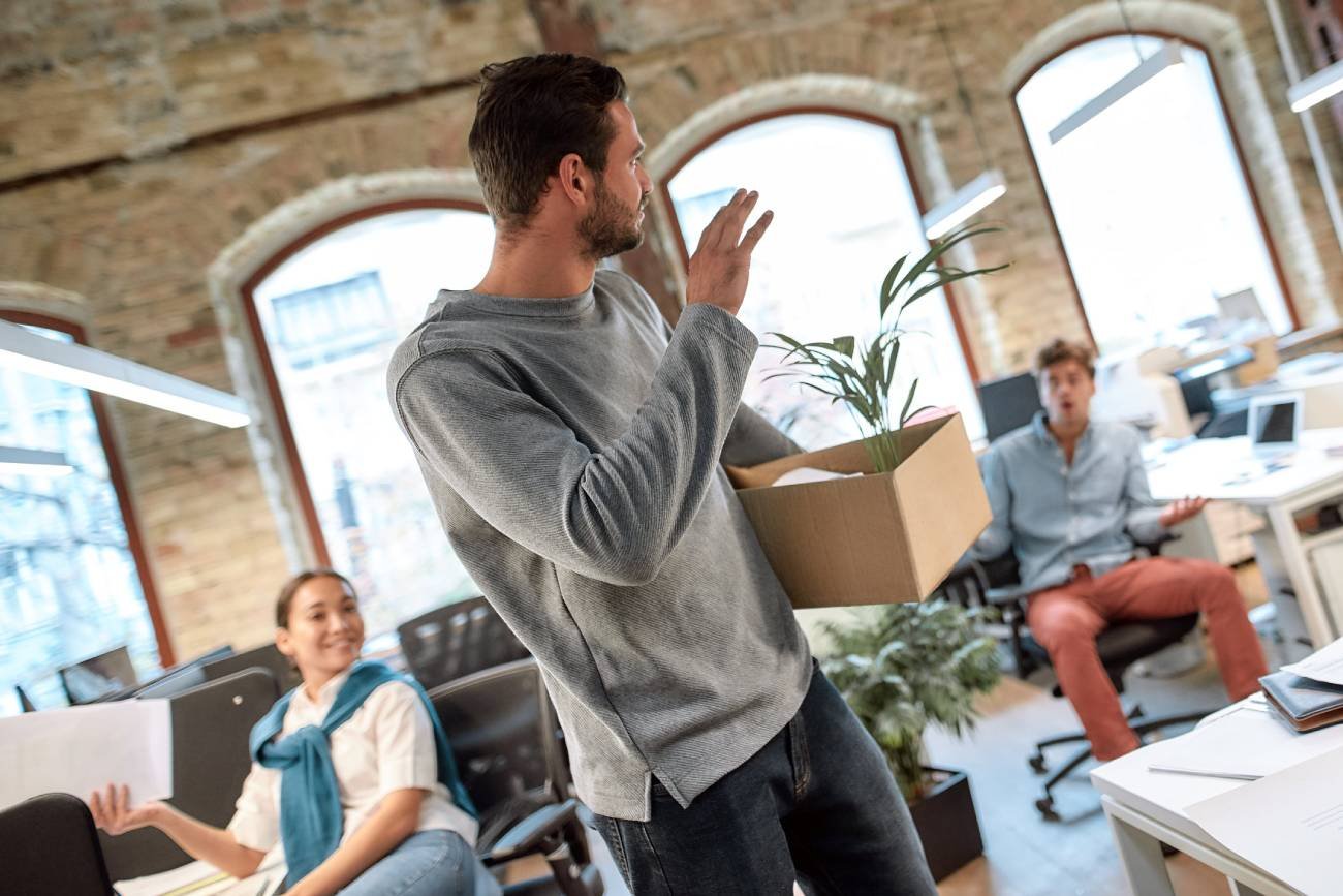 Młody pracownik odchodzi z biura. Inni pracownicy w szoku.