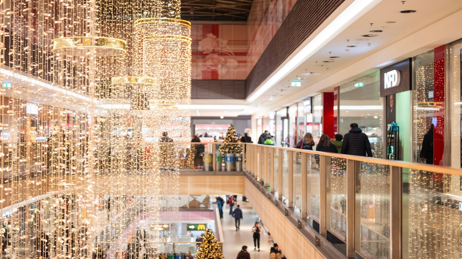 Ten sam produkt, ale inna cena. Czy sklepy stacjonarne robią z nas idiotów? Galeria handlowa w Krakowie ozdobiona w świąteczne dekoracje. Klienci galerii handlowej.