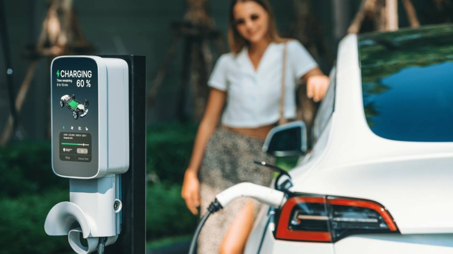 Kobieta przy stacji ładowania samochodu elektrycznego.