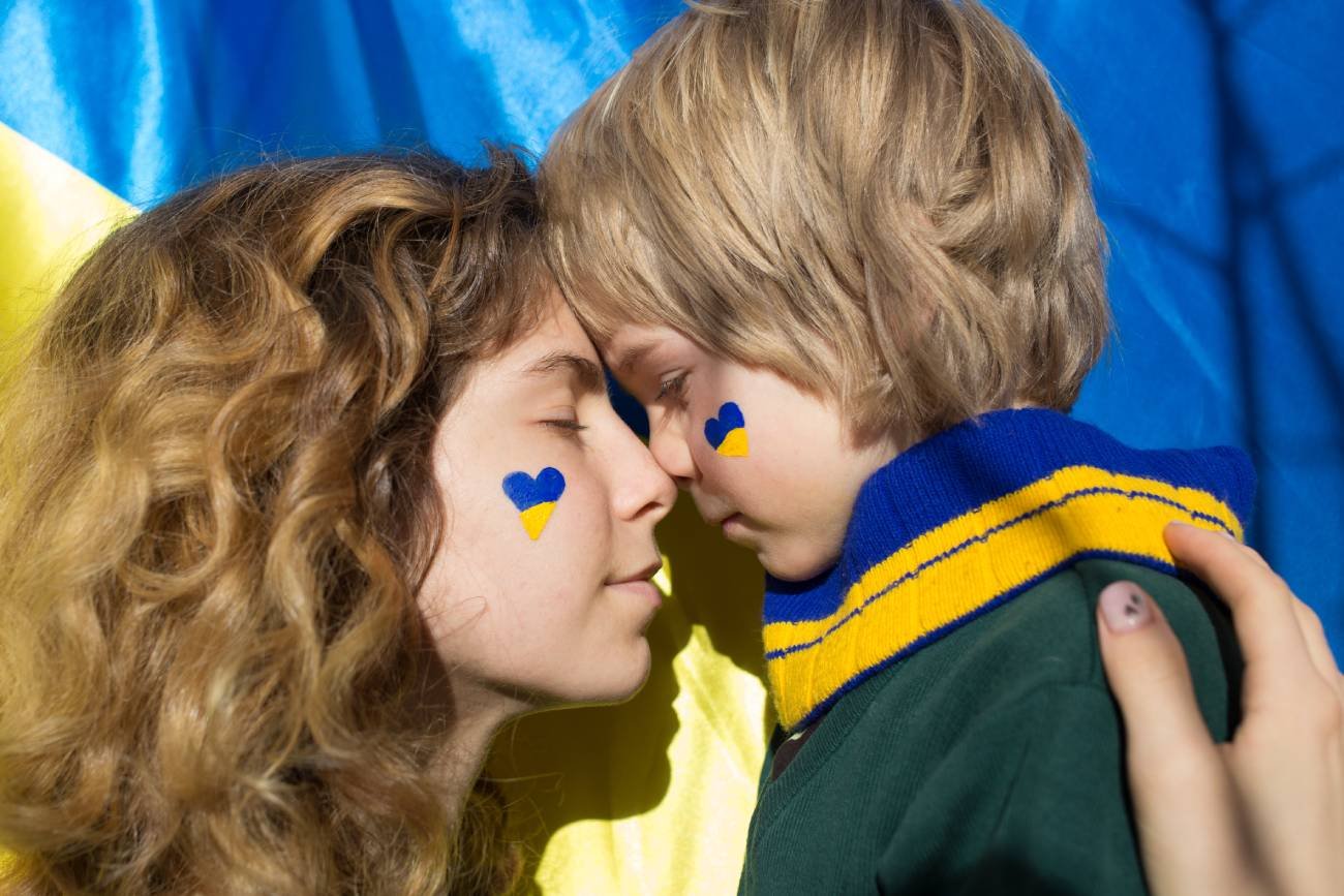 dziewczyna i chłopczyk na tle ukraińskiej flagi