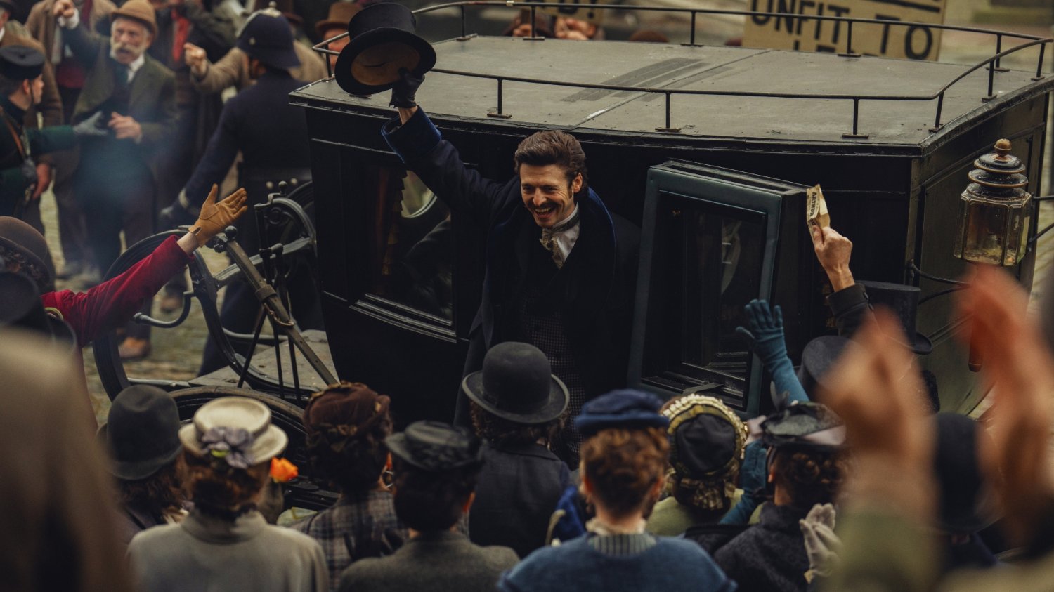 Mężczyzna wysiadający z dorożki macha tłumowi kapeluszem. Kadr z serialu "Ród Guinnessów" na Netflix.