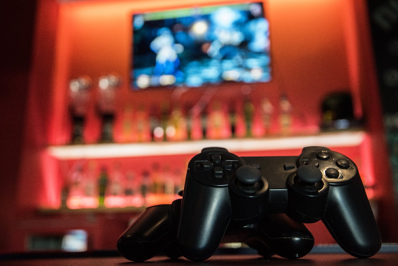 konsola do gier na czerwonym tle z telewizorem i pucharami za wygraną