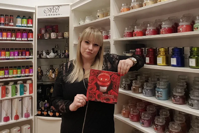 Magdalena Tarajda-Medes, dyrektor ds. PR i mediów w Aromanti, prezentuje jeden z produktów z asortymentu Village Candle. To marka amerykańskich świec zapachowych, których czas palenia wynosi nawet 170 godzin