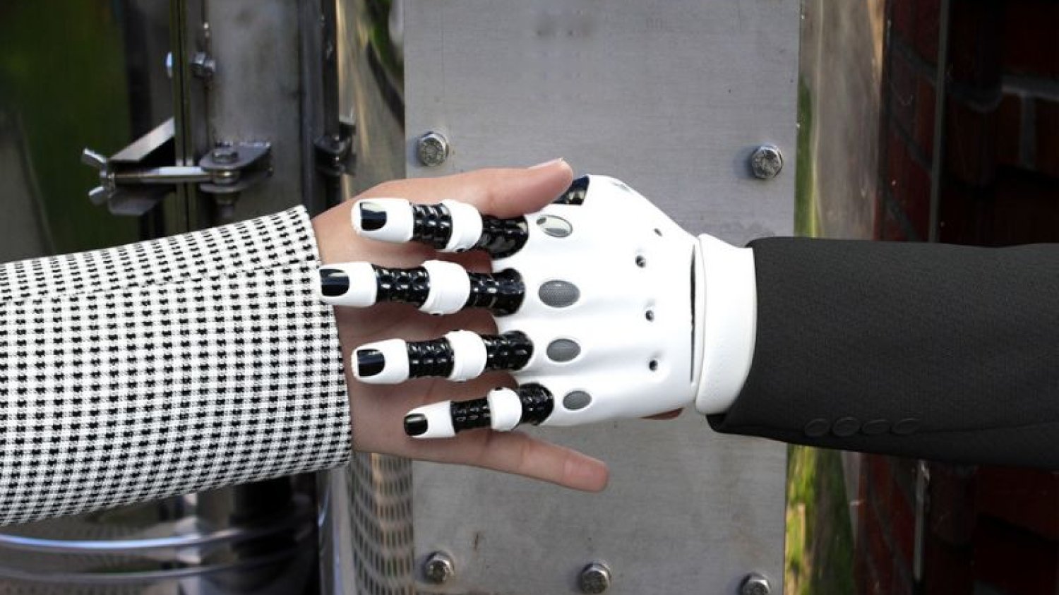 Uścisk ludzkiej dłoni i ręki robota.