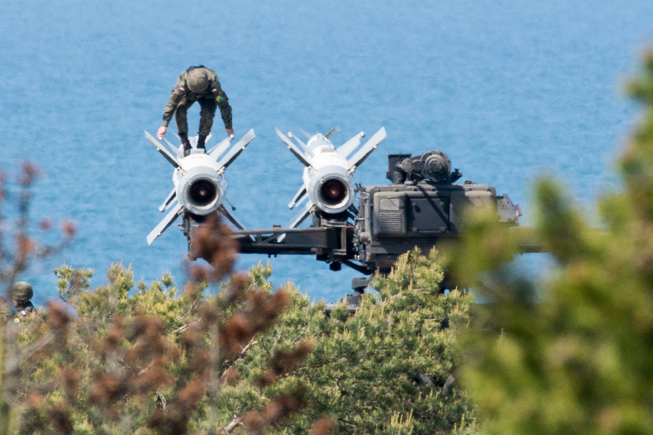 Centralny Poligon Sił Powietrznych z żołnierzem na zdjęciu wspinającym się po sprzęcie obrony przeciwlotniczej