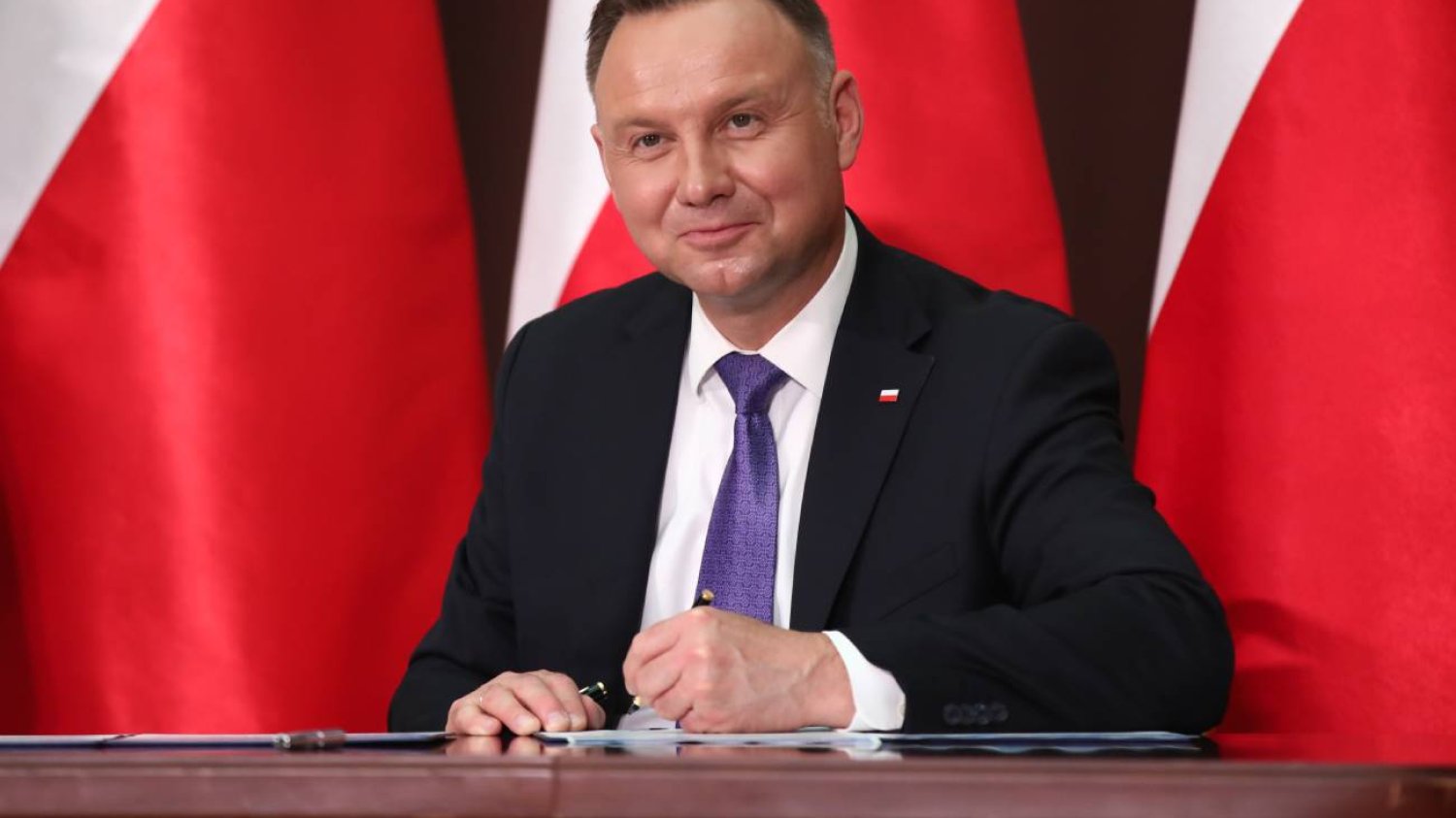 Prezydent Andrzej Duda podpisuje dokument.