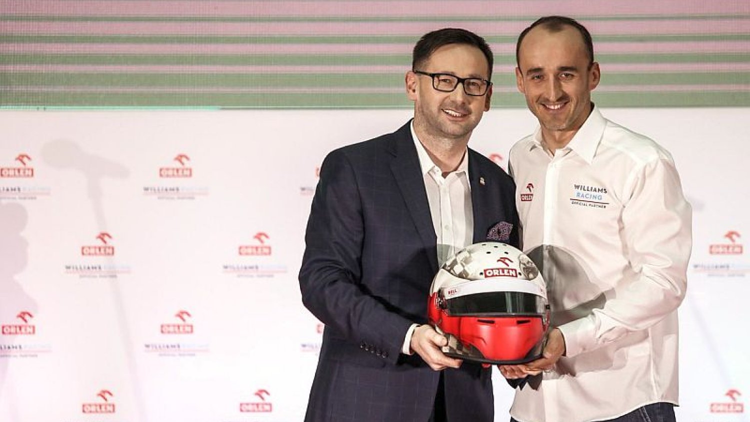Prezes Orlenu Daniel Obajtek i Robert Kubica pokazują kask, w którym będzie się ścigał nasz rodak