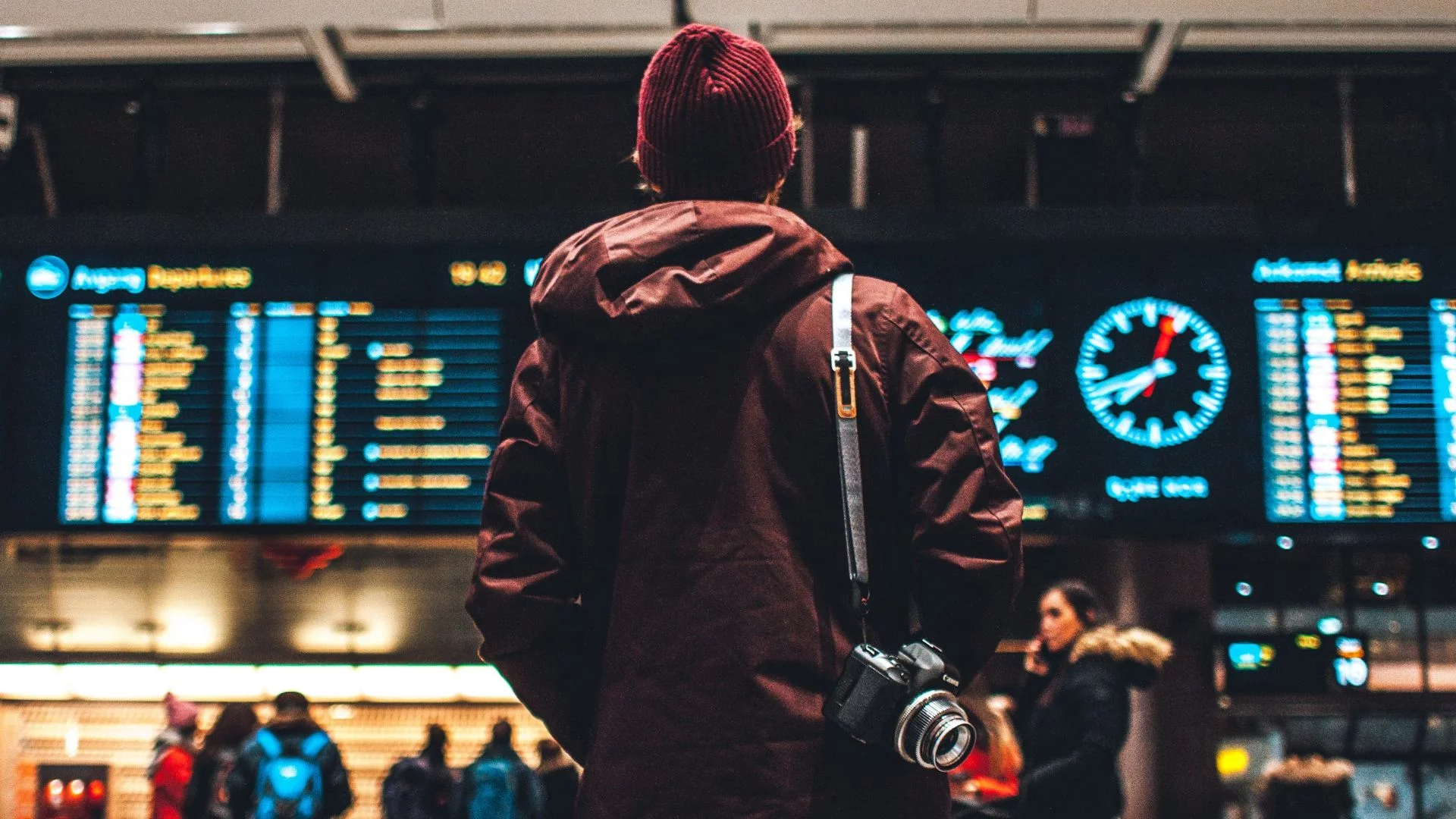 Lotnisko, osoba stoi przed tablicą z harmonogramem odlotów i przylotów. Berlińskie lotnisko ostrzega. Dalej boryka się ze skutkami cyberataku.