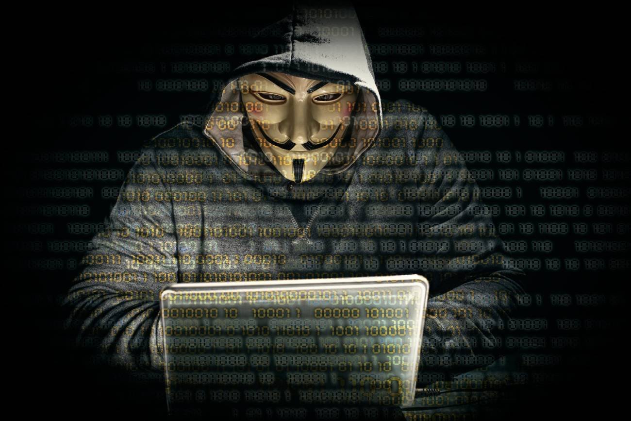 Anonymous. Haker przed komputerem.