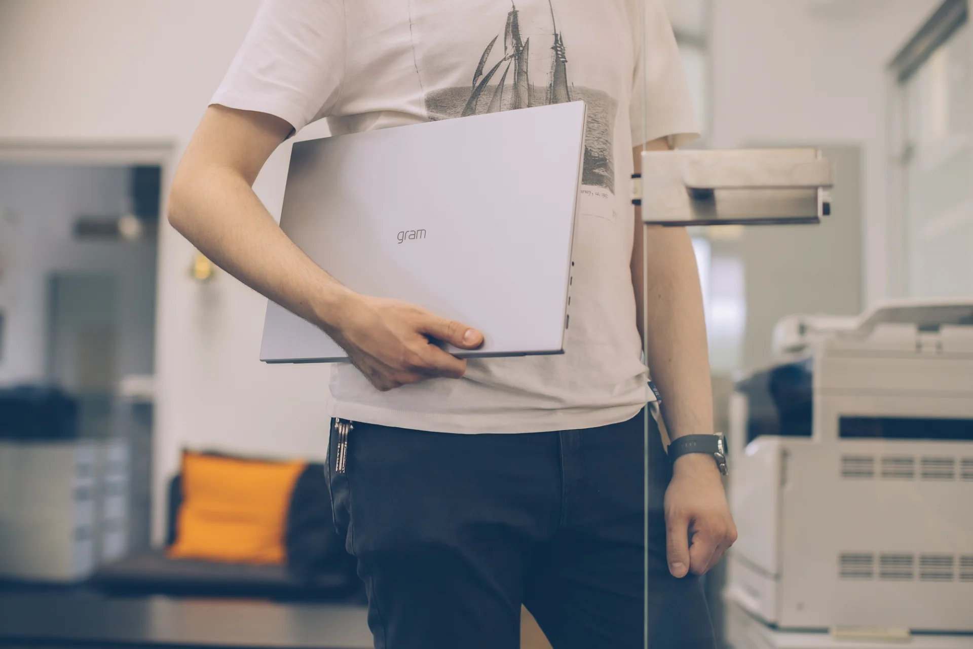 LG Gram w środowisku biurowym. Laptop pod pachą mężczyzny.