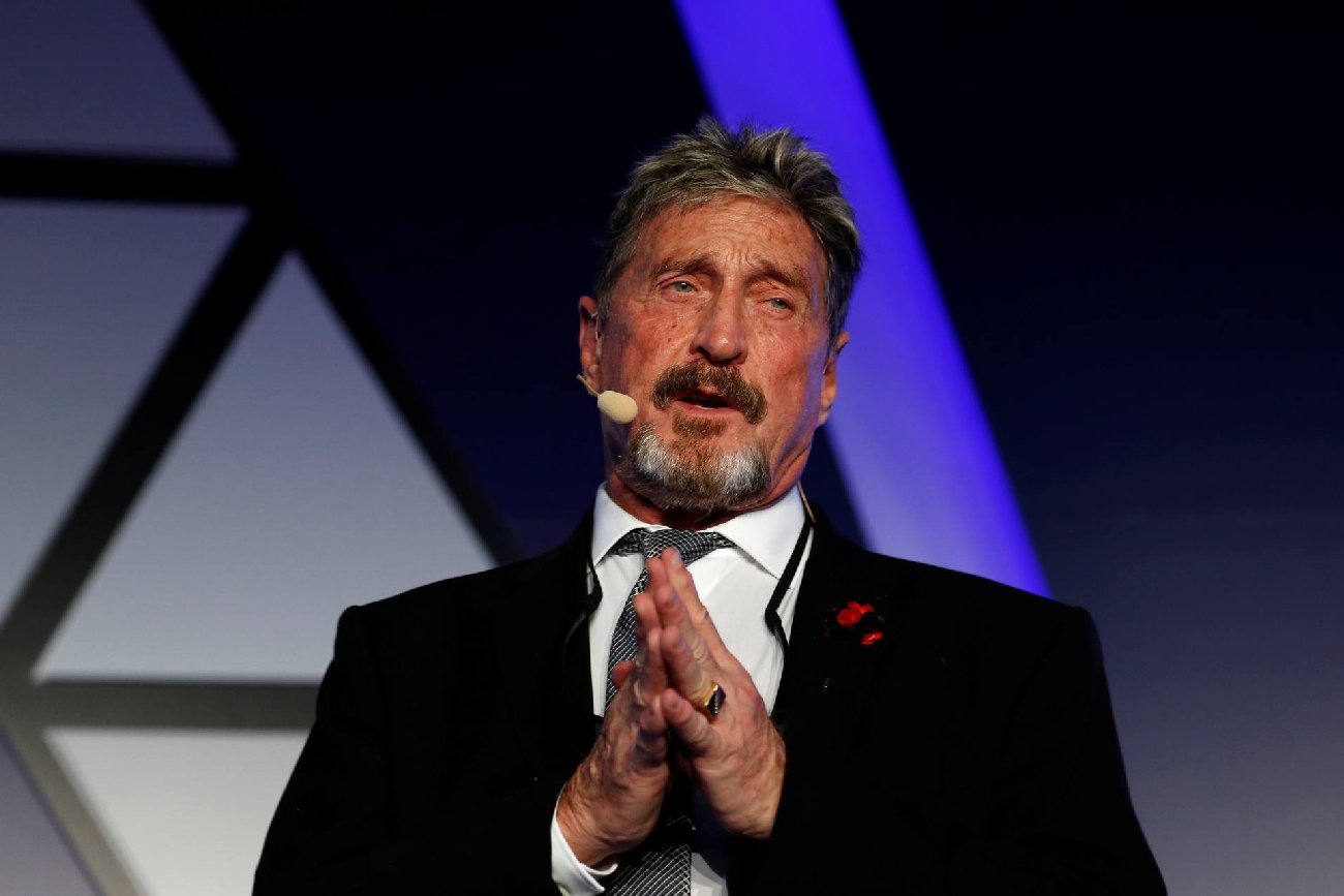John McAfee w garniturze podczas wystąpienia publicznego