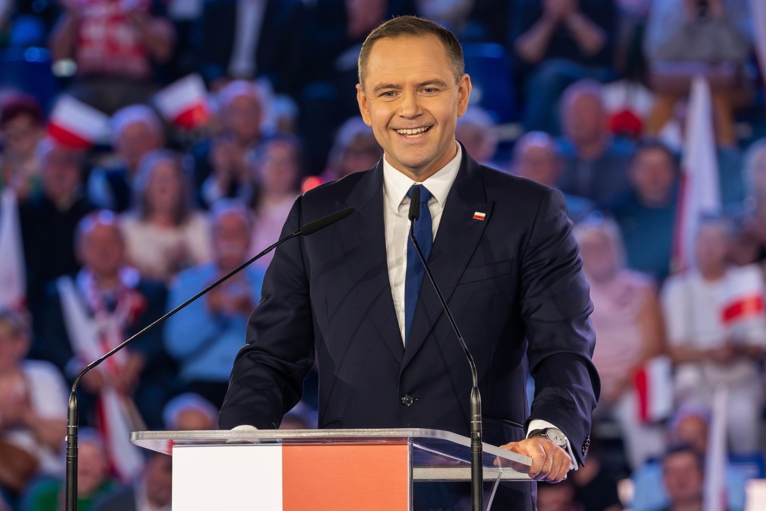 Uśmiechnięty Karol Nawrocki przemawia.