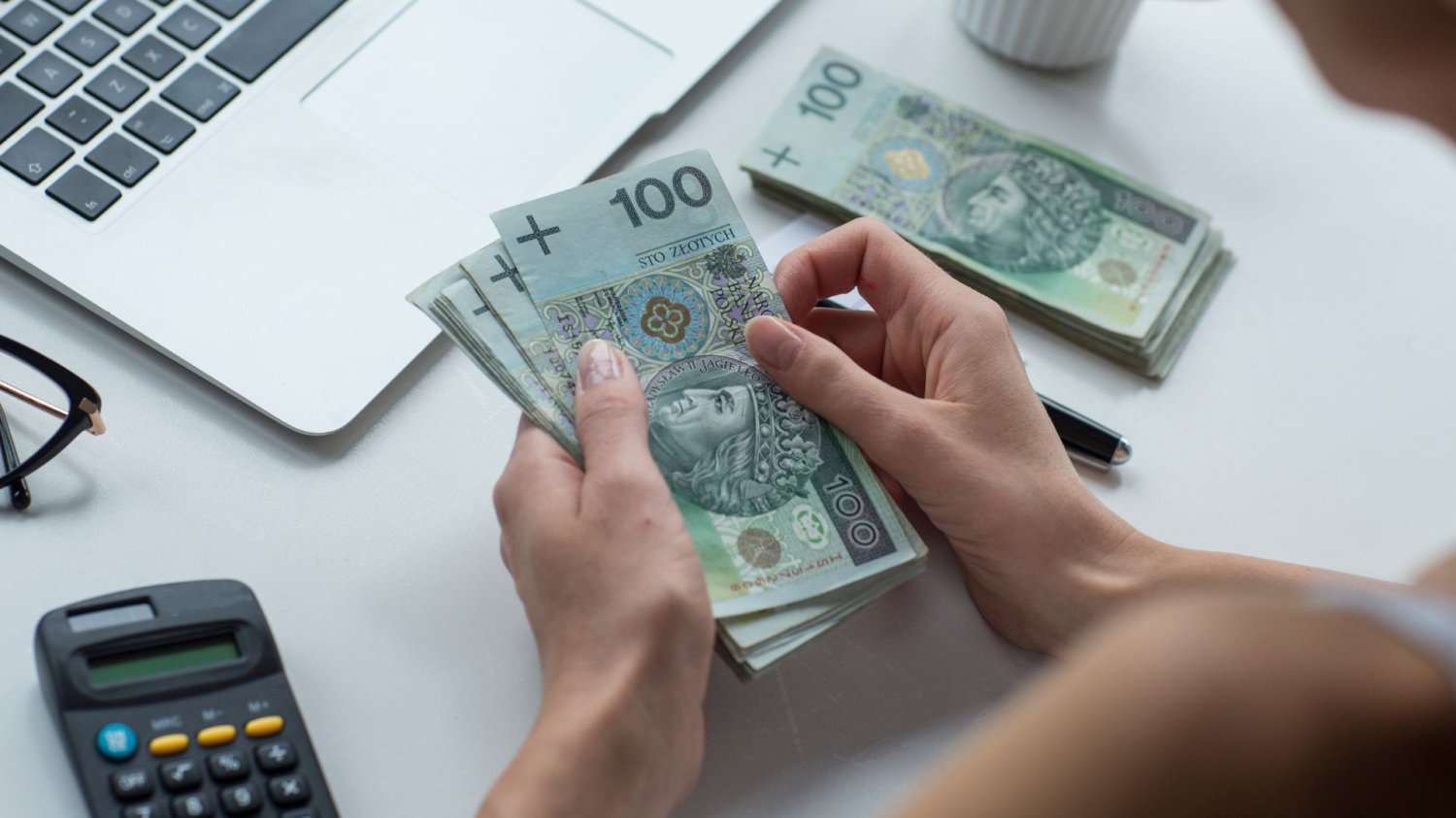Działalność gospodarcza będzie łatwiejsza. Koniec z lataniem po urzędach Człowiek przed laptopem przeliczający pieniądze. Działalność gospodarcza bez zbędnych formalności. Koniec z lataniem po urzędach