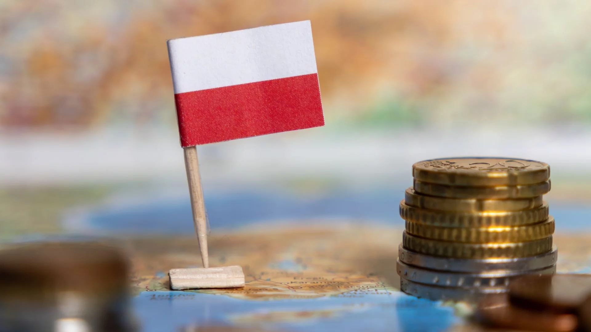 Koniec polskiego cudu gospodarczego? Raport Banku Światowego jak kubeł zimnej wody mała polska flaga na mapie i przy stosiku monet