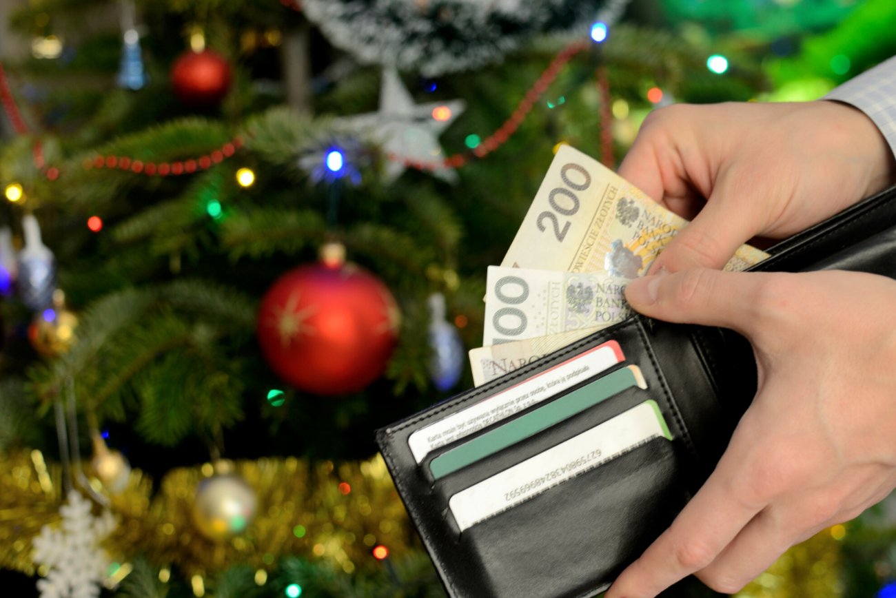 Portfel z pieniędzmi na tle choinki