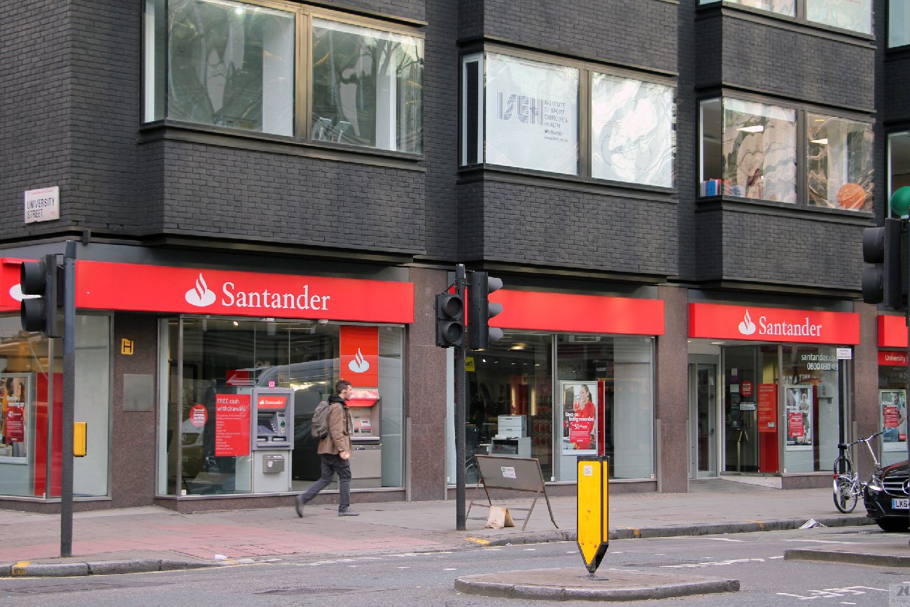Przechodzień idący obok budynku Santander Bank