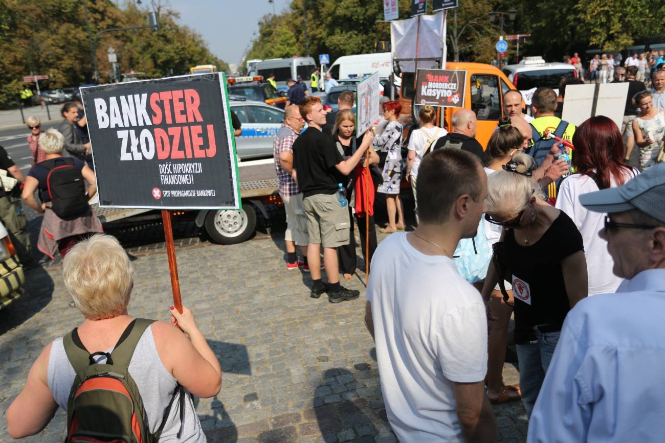 Protest frankowiczów, widoczny baner z napisem "Bankster złodziej"