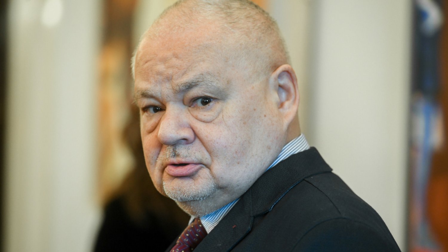 Adam Glapiński uchwycony przez fotografa, twarz bez uśmiechu pozująca do obiektywu