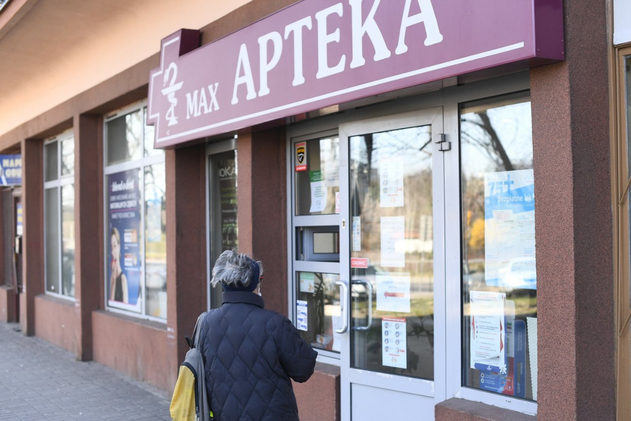 Kobieta przed apteką.