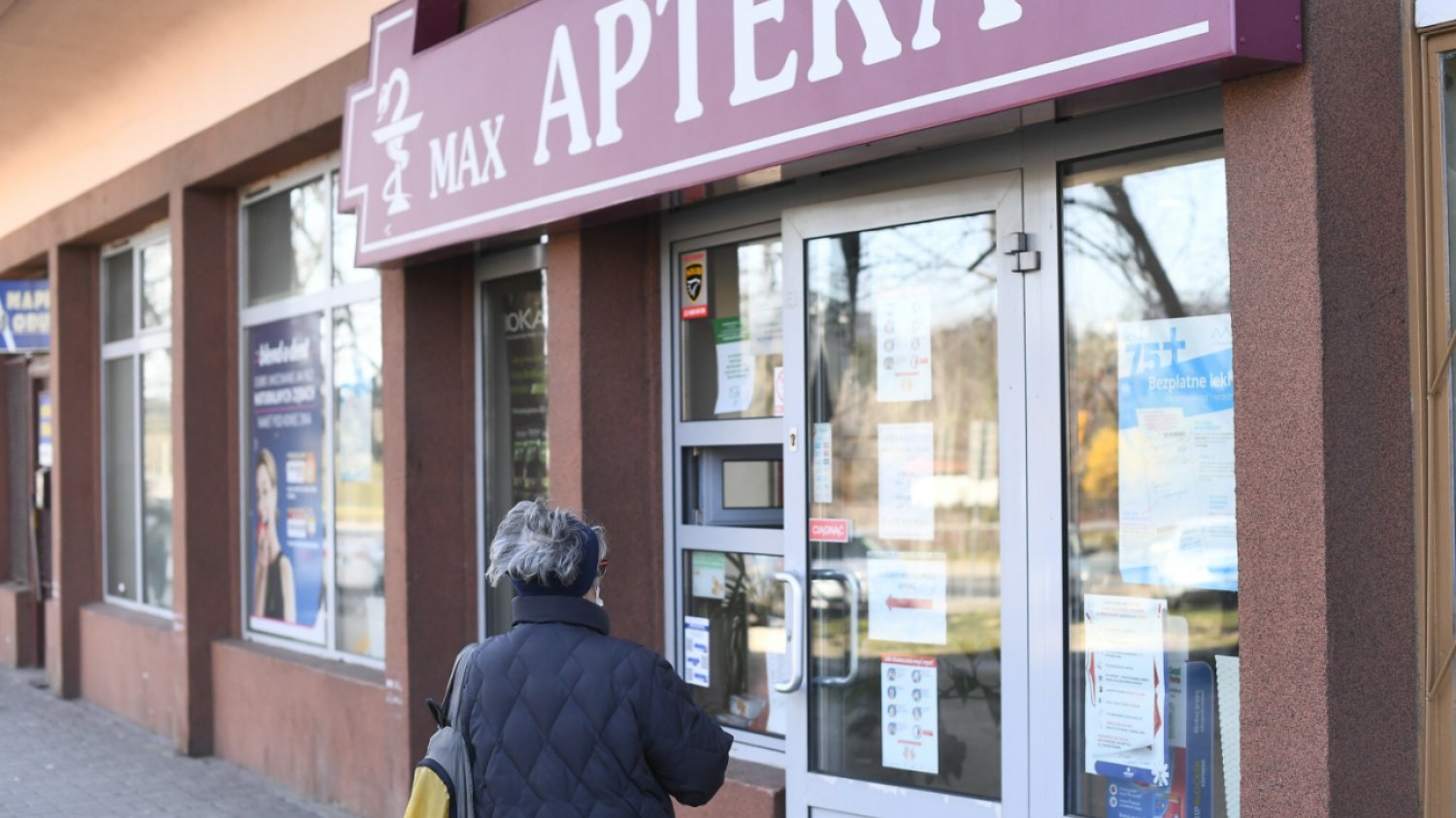 Kobieta przed apteką.