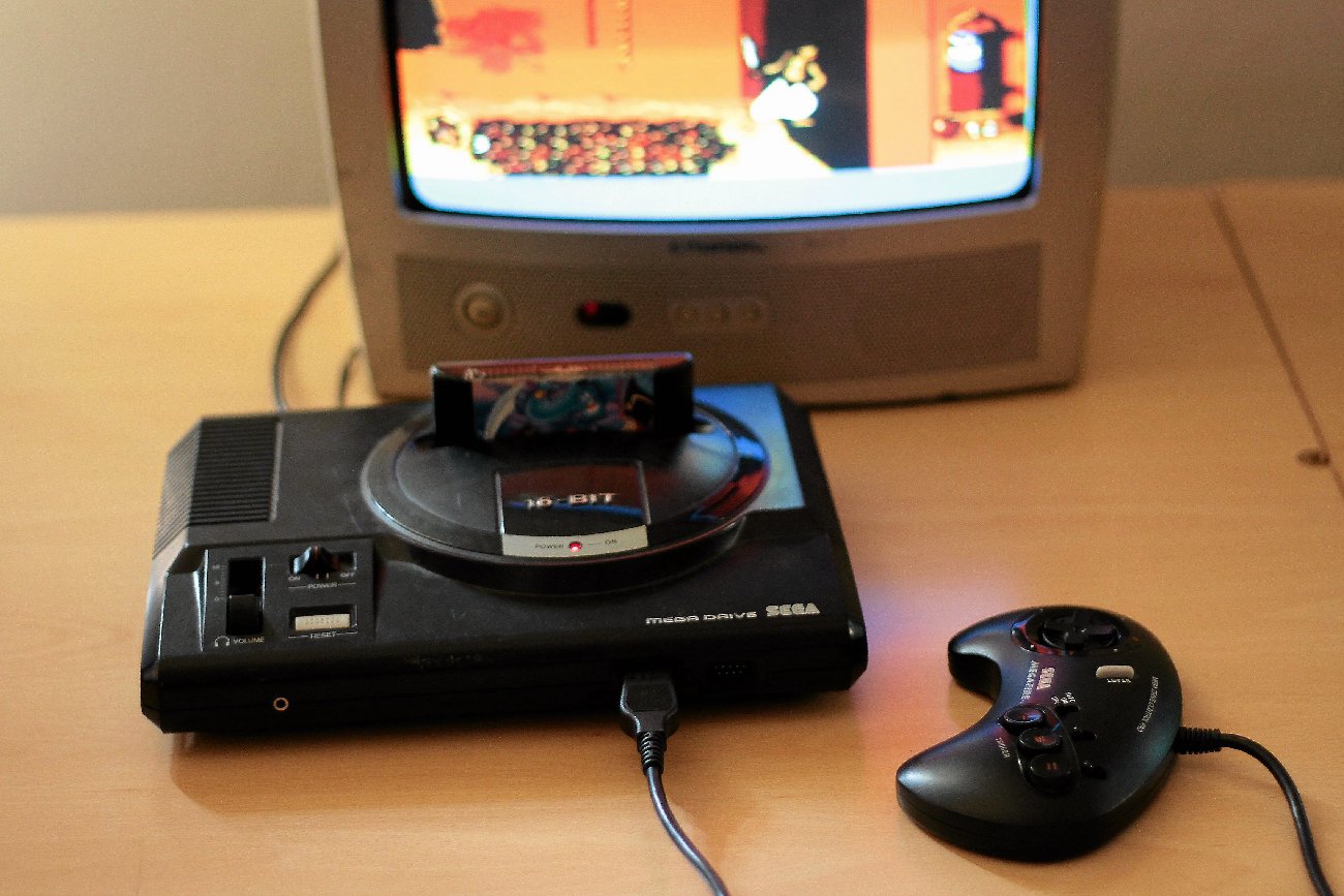 stara konsola do gry leży na drewnianym stole przed telewizorem