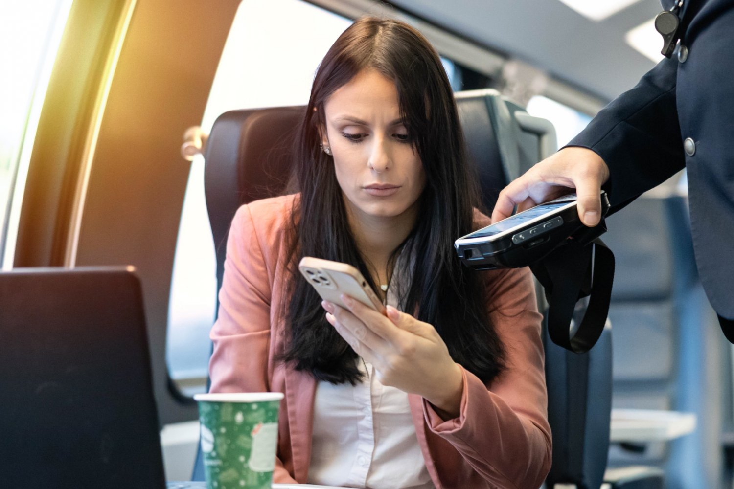 Kobieta pokazuje bilet w telefonie konduktorowi.