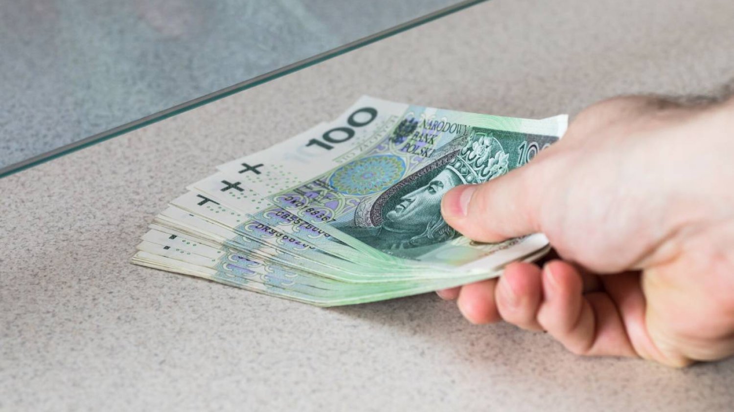 ręka z plikiem banknotów